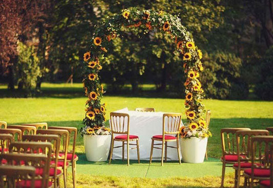 Toile de fond d'herbe verte de printemps et d'arc de tournesol jaune pour la photographie de cérémonie de mariage