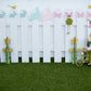 Toile de fond clôture blanche lapin papillon herbe décors de Pâques pour la photo